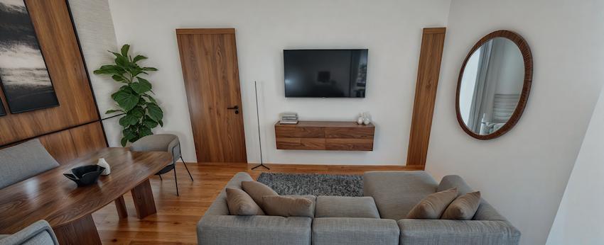 Sala con sofá, mesa de centro de madera y mueble de TV flotante